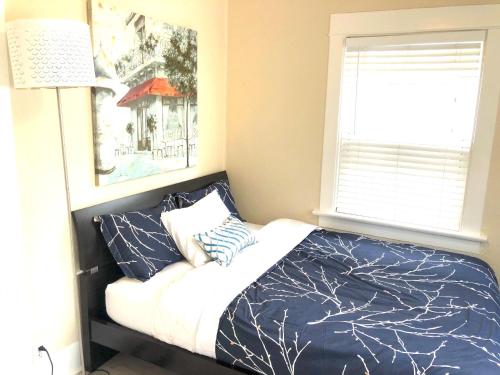 a bedroom with a bed with blue and white sheets and a window at Viva San Diego in San Diego