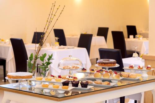 a table topped with different types of cakes and pastries at San Severino Park Hotel & SPA, BW Signature Collection in Mercato San Severino