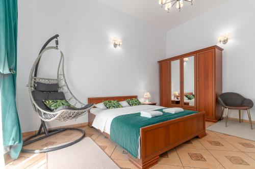 sypialnia z huśtawką i krzesłem w obiekcie Nasze Kamienice Apartament Muzyczny z antresolą w mieście Rzeszów