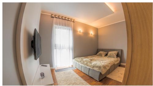 een slaapkamer met een bed en een raam bij Apartament 75,143 Porta Mare in Dziwnówek
