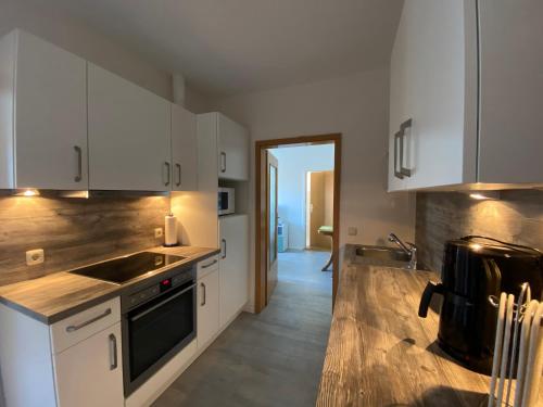 a kitchen with white cabinets and a stove top oven at Hotel Thode in Dahme