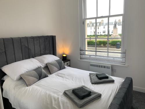 a bedroom with a large bed with two towels on it at Ayr Cozy Corner Apartment in Ayr