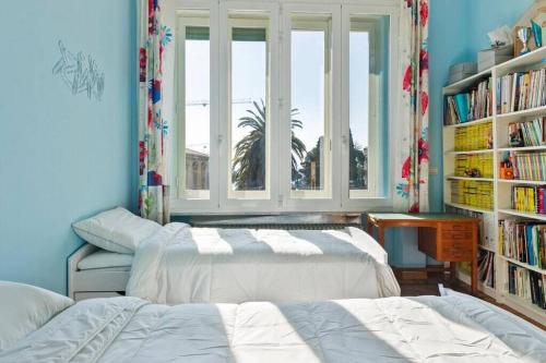 1 dormitorio con 2 camas y una estantería con libros en Villa Vale en San Remo