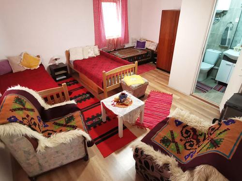 a living room with two couches and a table at "Pivnica i smestaj Jovanovic"- Rogljevacke pivnice in Rogljevo