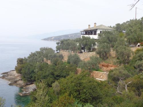 ein Haus auf einem Hügel neben dem Wasser in der Unterkunft Sea Front in Milína