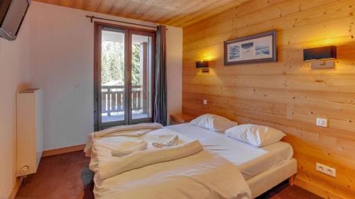 a bedroom with a large bed in a wooden wall at Appartement vue sur les montagnes Suisses in Vallorcine