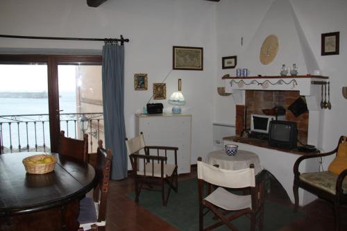 a living room with a table and a fireplace at Monolocale 'la Fenetre' - una grande finestra sul mare in Marciana Marina