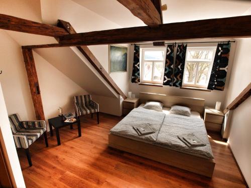 a bedroom with a bed and a staircase at Hotel Pod Kokšínem in Spálené Poříčí