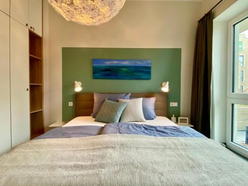 a bedroom with a large bed and a chandelier at Apartment Waterkamp, 26316 Dangast in Dangast