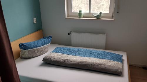a bedroom with a bed with blue sheets and a window at Stadthotel am Bühnenhaus in Kevelaer