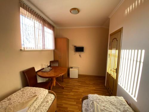 a room with a table and a bed and a table and chairs at Ковчег in Chernivtsi