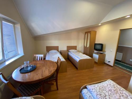 a room with two beds and a table and a dining room at Ковчег in Chernivtsi