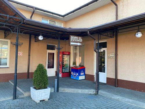 a store front with a potted tree in front of it at Ковчег in Chernivtsi