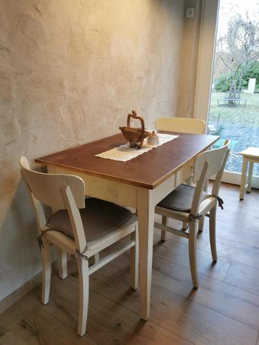 a wooden table with two chairs and a bowl on it at Gästehaus Vergissmeinnicht in Guteborn