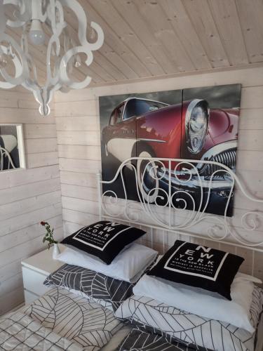 ウストカにあるDomki LA MERのベッド2台と車のポスターが備わる部屋