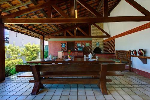 a pavilion with a bench on a patio at Casa no centro de Cumbuco por Carpediem in Caucaia