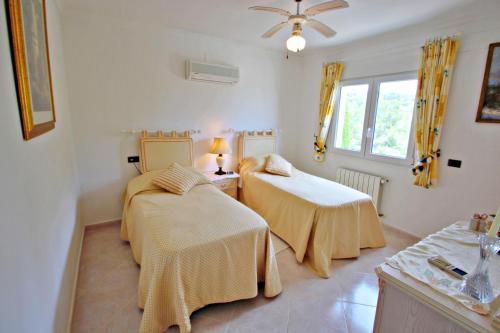 een kamer met 2 bedden en een raam bij El Sol - luxury villa with private pool in Benissa in Teulada
