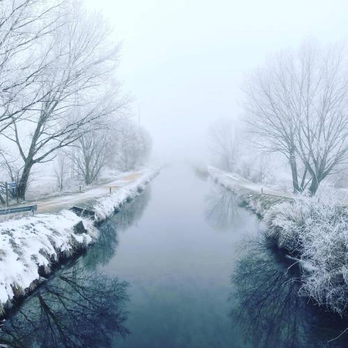 a river covered in snow with trees in the background at Motel Emporio in Cabezón de Pisuerga