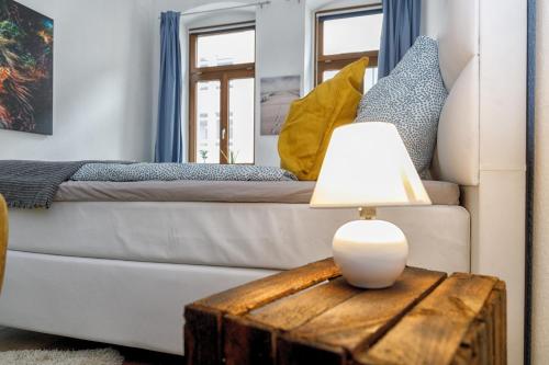 uma sala de estar com um sofá e uma mesa com um candeeiro em Blue Chili 20 - Zentral in der CITY WLAN bis 4 Pers em Magdeburg