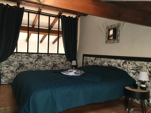 une chambre avec un lit bleu et une fenêtre dans l'établissement Corse Appartement vue mer - Linguizzetta - Marine de Bravone, à Linguizzetta