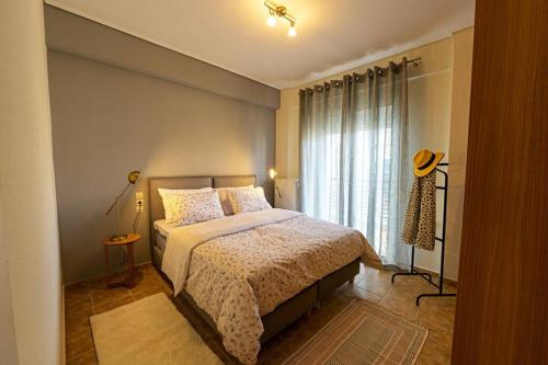 a bedroom with a bed and a large window at Karamba boutique living - ECO Riverside Appartment in Volos