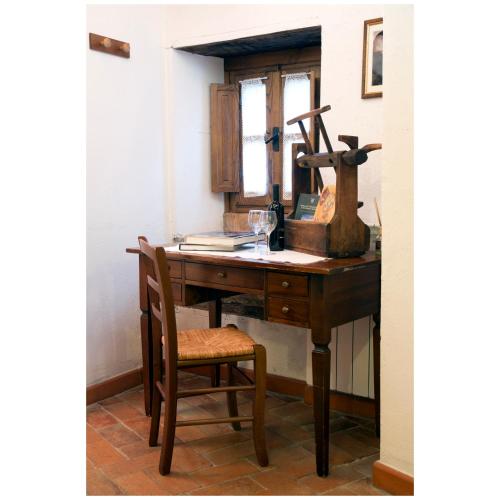 a wooden desk with a chair and a mirror at Agriturismo Montagna Verde Apella in Licciana Nardi