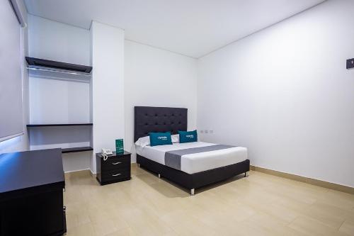 a bedroom with a bed and a desk in it at Ayenda Hotel Trinidad in Montería