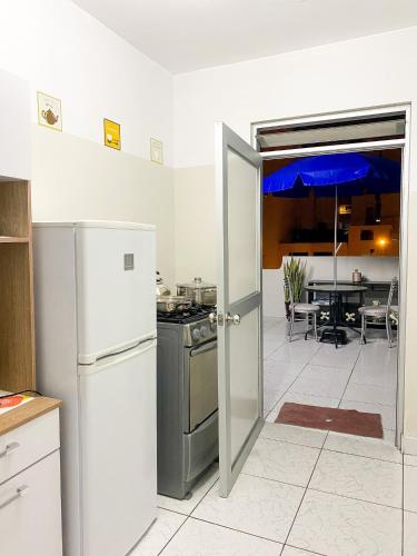 cocina con nevera y puerta abierta en Apartamento Independiente 1 dormitorio cama Queen, en Lima