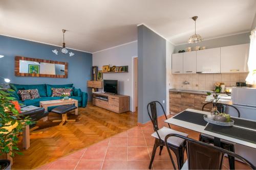 uma sala de estar e cozinha com um sofá azul em Apartment Green 29 em Rovinj