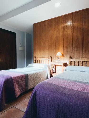 Zwei Betten in einem Hotelzimmer mit lila Bettwäsche in der Unterkunft Hotel Valdevécar in Albarracín