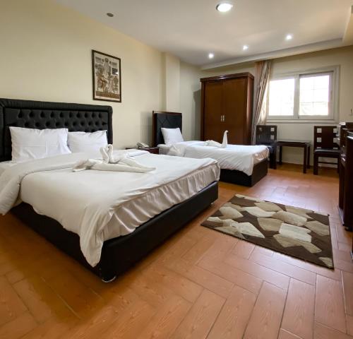 a hotel room with two beds and a desk at Best View Pyramids Hotel in Cairo