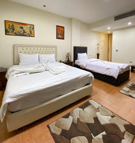 a bedroom with two beds and a rug at Best View Pyramids Hotel in Cairo