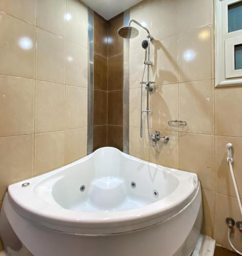 a white tub in a bathroom with a shower at Best View Pyramids Hotel in Cairo