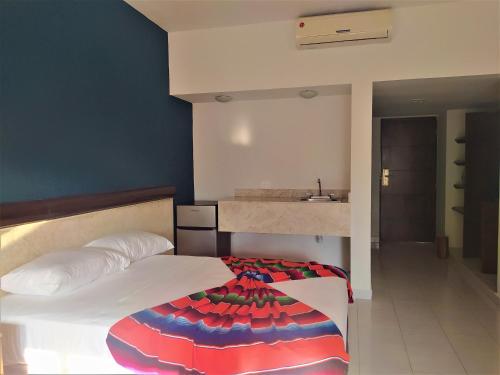 a bedroom with a bed and a sink in it at Hotel Mariachi by Kavia 5th Av in Playa del Carmen