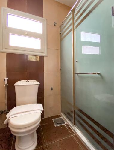 a bathroom with a toilet and a window and a shower at Best View Pyramids Hotel in Cairo