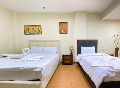 two beds sitting next to each other in a bedroom at Best View Pyramids Hotel in Cairo