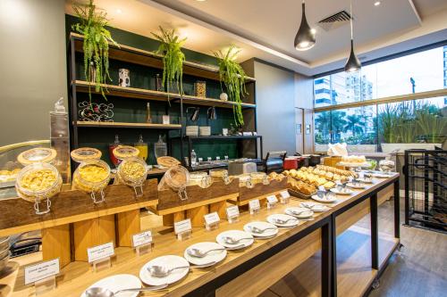 弗洛里亚诺波利斯Mercure Florianópolis的摆放着盘子和玻璃杯的自助餐线