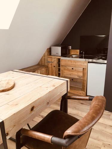 une cuisine avec une table en bois et deux chaises dans l'établissement Studio Escapade Normande proche Etretat, à Saint-Jouin-Bruneval