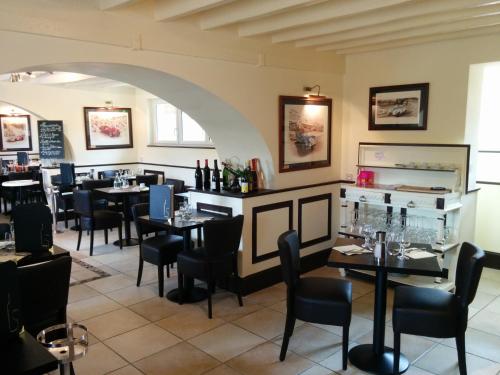 a restaurant with tables and chairs in a room at Relais Henri IV in La Flèche