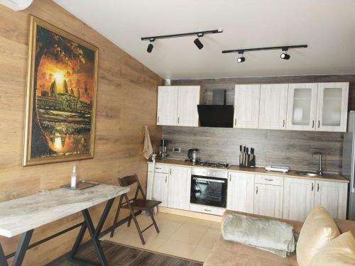 a kitchen with white cabinets and a large painting on the wall at Kambodzha na Dynae in Vylkove