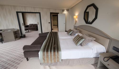 a bedroom with a large bed and a couch at Hotel Bahía in Santander