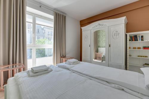sypialnia z 2 białymi łóżkami i dużym oknem w obiekcie Comfort Apartments Kwartał Kamienic w Gdańsku