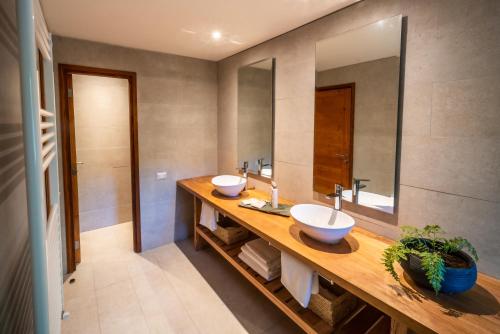 a bathroom with two sinks and a large mirror at Rakau Lodge in Pucón