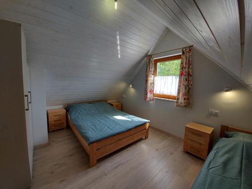 a room with two beds and a window in a attic at Agroturystyka Pod Klonem in Wąglikowice