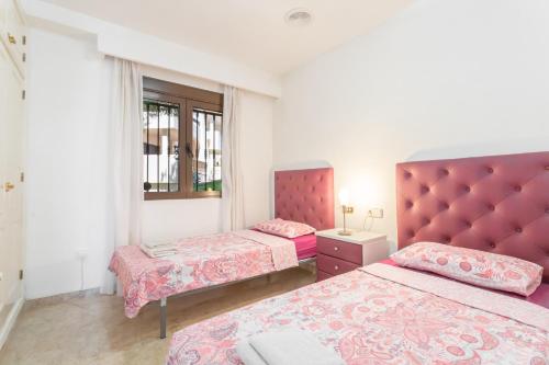 1 dormitorio con 2 camas y cabecero rojo en Appartement Orihuela Costa Golf, Las Ramblas, en Villacosta