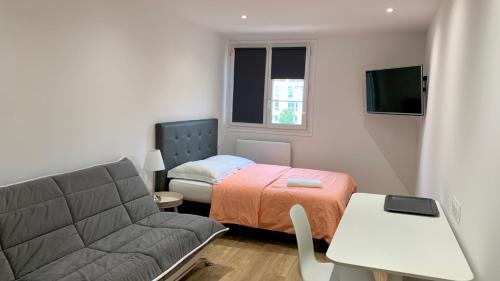 une petite pièce avec un lit et un canapé dans l'établissement Nanterre Room, à Nanterre