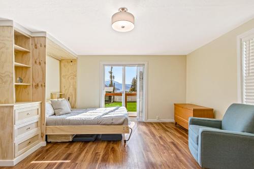 a bedroom with a bed and a couch and a window at Bayview Tiny Cabin in Athol