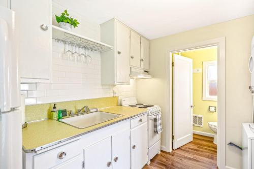 uma cozinha com armários brancos e um lavatório em Bayview Tiny Cabin em Athol