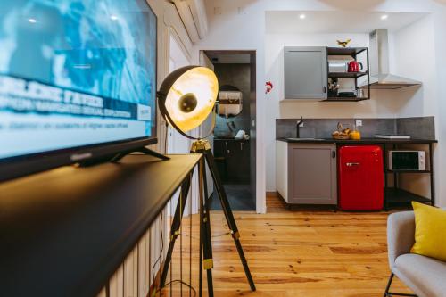 a living room with a television and a kitchen at 19 Tile Ceramic Concept - by Unlock Hotels in Caldas da Rainha