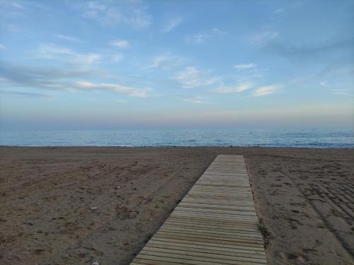 a wooden pathway on a beach with the ocean at Apartamento Bolnuevo (Mazarrón) in Bolnuevo